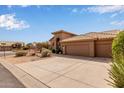 Lovely home featuring a tile roof, desert landscaping, and an extended driveway with a three-car garage at 9393 E Hunter Ct, Scottsdale, AZ 85262