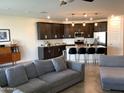 Open-concept living room with a view into the kitchen and comfortable grey sectional at 9804 E Red Giant Dr, Mesa, AZ 85212