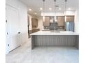 Open kitchen with gray cabinets, stainless steel appliances, a tile backsplash, and an island with a quartz countertop at 1 Easy St # 6, Carefree, AZ 85377