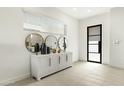 Bright entryway featuring a decorative console table, round mirrors, and a modern door, creating a welcoming ambiance at 1 Easy St # 7, Carefree, AZ 85377