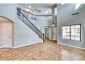 Grand entryway featuring a soaring ceiling, tiled floor, and staircase with decorative black metal banister at 15033 W Statler St, Surprise, AZ 85374