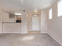 Neutral toned living room features modern ceiling fan, carpet, and an opening to the kitchen at 20100 N 78Th Pl # 1013, Scottsdale, AZ 85255