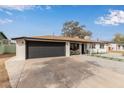 A bright white single-story home features a wide driveway and manicured front yard with rock at 2502 W Freeway Ln, Phoenix, AZ 85021