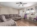 Comfortable living room features laminate flooring, neutral wall paint, and a stylish ceiling fan at 2502 W Freeway Ln, Phoenix, AZ 85021