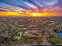 Expansive aerial view of a desert estate showcasing a resort-style pool, sports court, and vibrant sunset backdrop at 27632 N 68Th Pl, Scottsdale, AZ 85266