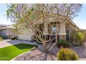 Landscaped front yard of a charming home with mature trees, stone, and verdant lawn at 2807 W Canada De Oro Rd, Queen Creek, AZ 85144