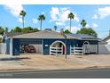 Charming blue home with an open garage, basketball hoop, desert landscaping, and solar panels at 3224 E Sweetwater Ave, Phoenix, AZ 85032