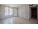 Neutral living room featuring tile flooring, a large window, and access to other rooms at 3646 N 67Th Ave # 12, Phoenix, AZ 85033
