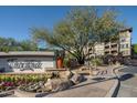 A welcoming entrance sign with flowers and landscaping creates a picturesque arrival at 5350 E Deer Valley Dr # 1253, Phoenix, AZ 85054