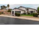 Suburban home with a three-car garage, arched entryway, and manicured landscaping at 6155 E Karen Dr, Scottsdale, AZ 85254