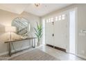 Bright foyer with large circular mirror, console table, and view of the staircase at 8100 E Camelback Rd # 143, Scottsdale, AZ 85251