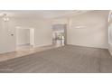 Spacious living room with neutral carpeting, arched doorways, and modern lighting fixtures at 1182 E Harrison St, Gilbert, AZ 85295