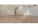 Open living room with tile floors, shiplap accent wall, staircase and doorway at 12056 W Melinda Ln, Sun City, AZ 85373