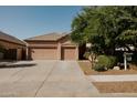 Charming single-story home features a spacious three-car garage and well-manicured front yard at 13542 W Port Au Prince Ln, Surprise, AZ 85379