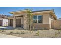 Cozy single-story home with a two-car garage, well-manicured landscaping, and a welcoming covered entry at 15005 W Gray Fox Trl, Surprise, AZ 85387