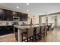 Open kitchen with a large island, granite countertops, and stainless steel appliances at 15658 W Cortez St, Surprise, AZ 85379