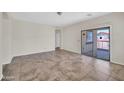 Bright, open living room features tile flooring and a sliding glass door leading to outdoor area at 17008 W Sonora St, Goodyear, AZ 85338