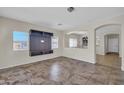 Spacious living room with tile flooring, media center, and great natural light from large windows at 17008 W Sonora St, Goodyear, AZ 85338