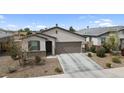 Inviting home featuring a two-car garage, desert landscaping, and a covered entry at 1924 S 82Nd Cir, Mesa, AZ 85209