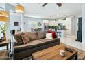 Open-concept living room with a large sofa, modern lighting fixtures, and seamless flow into the adjacent kitchen at 2169 N 212Th Ln, Buckeye, AZ 85396