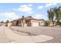 A spacious single-Gathering house showcasing a large front yard with desert landscaping and a two-car garage at 28321 N Zircon Dr, San Tan Valley, AZ 85143