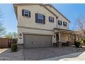 Two-story home features a two-car garage, neutral stucco, and a brick-paved driveway and walkway at 2943 W Thorn Tree Dr, Phoenix, AZ 85085