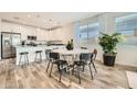 Stylish kitchen and dining area featuring a breakfast bar, stainless steel refrigerator, and wood-style floors at 3396 E Open Prairie Dr, San Tan Valley, AZ 85140