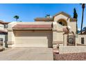 View of two-car garage, tiled roof, rock landscaping and secured gate entrance at 448 E Wescott Dr, Phoenix, AZ 85024