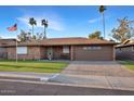 Well-maintained brick house featuring a two-car garage and a neatly paved driveway, all under a clear sky at 4729 E Dolphin Ave, Mesa, AZ 85206