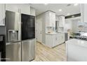Updated kitchen featuring stainless steel fridge and fixtures, complemented by white cabinetry at 4938 W Tuckey Ln, Glendale, AZ 85301