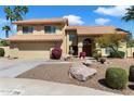 Charming front exterior showcasing a two-story home, desert landscape, and unique water feature at 5530 E Beck Ln, Scottsdale, AZ 85254