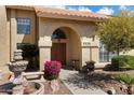 Inviting front entrance with an arched doorway, beautiful desert plants, and a decorative water feature at 5530 E Beck Ln, Scottsdale, AZ 85254