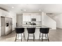 Bright kitchen with white cabinets, stainless steel appliances, and large island with seating at 6823 W Getty Dr, Phoenix, AZ 85043