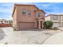 Two-story home featuring a two-car garage, neutral colored stucco, and desert landscaping at 6925 W Maldonado Rd, Laveen, AZ 85339