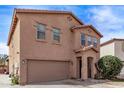 Two-story home featuring a two-car garage, neutral colored stucco, and a covered front porch at 6925 W Maldonado Rd, Laveen, AZ 85339