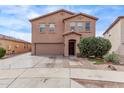 Two-story home featuring a two-car garage, neutral colored stucco, and desert landscaping at 6925 W Maldonado Rd, Laveen, AZ 85339