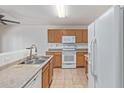 Traditional kitchen with tile floors, white appliances, and plenty of cabinet space at 7359 W Rancho Dr, Glendale, AZ 85303