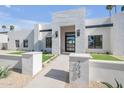 Contemporary home with a light stone entryway, modern address numbers, and a well-manicured lawn at 7939 E Via Linda --, Scottsdale, AZ 85258
