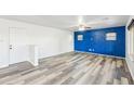 Spacious living room with wood floors, decorative blue wall, and ample natural light at 1227 W Avalon Canyon Dr, Casa Grande, AZ 85122