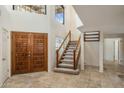 Bright entryway featuring a decorative front door, tiled floor, and staircase leading to the second level at 1327 E Le Marche Ave, Phoenix, AZ 85022