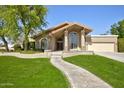 Charming single Gathering home featuring an arched entry, desert landscaping, and two car garage at 1530 E Jeanine Dr, Tempe, AZ 85284