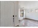 Bright entryway with modern gray wood flooring, a white door, and a view into the home at 15365 W Valentine St, Surprise, AZ 85379