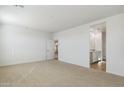Large primary bedroom featuring plush carpet, ensuite bath, and a bright, airy feel at 15381 W Cottontail Ln, Surprise, AZ 85387