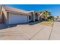 Single-story house featuring a two-car garage, desert landscaping, and a long driveway at 17402 N 45Th St, Phoenix, AZ 85032