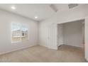 Bright bedroom with carpet flooring, a large window, and an adjoining bathroom at 17788 W Getty Dr, Goodyear, AZ 85338
