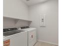 Clean laundry room with modern washer and dryer, shelving, and neutral wall paint at 17788 W Getty Dr, Goodyear, AZ 85338