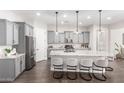 Modern kitchen featuring gray cabinets, granite countertops, stainless steel appliances, and an expansive island with bar seating at 1980 E Horseshoe Dr, Chandler, AZ 85249