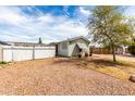 Charming home exterior with gravel landscaping, a white picket fence, and a lovely yard at 2145 N Silverton St, Mesa, AZ 85203