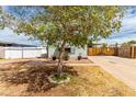 Charming home featuring well-maintained landscaping, a white picket fence and wide driveway at 2145 N Silverton St, Mesa, AZ 85203