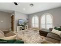 Cozy living room featuring neutral walls, arched windows and comfortable seating area with stylish rug at 2405 E Balboa Dr, Tempe, AZ 85282